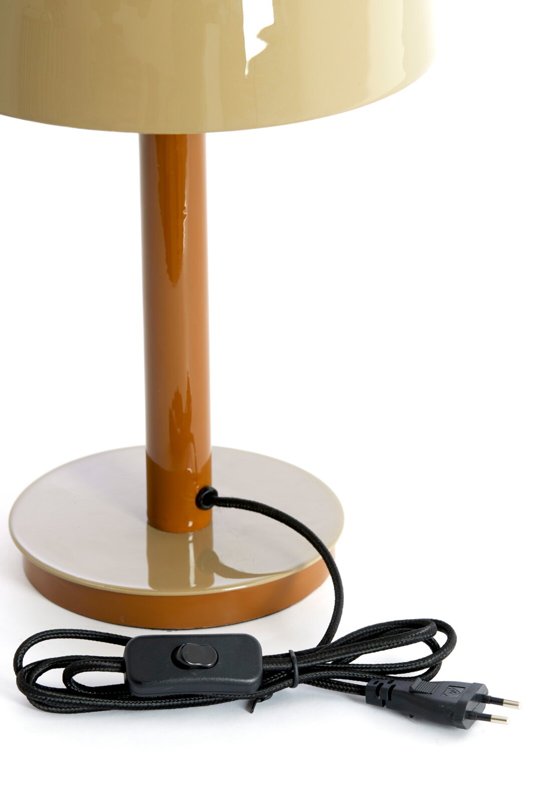 Close-up van een tafellamp met een bruine voet en een crèmekleurige kap, inclusief een zwarte kabel met schakelaar.