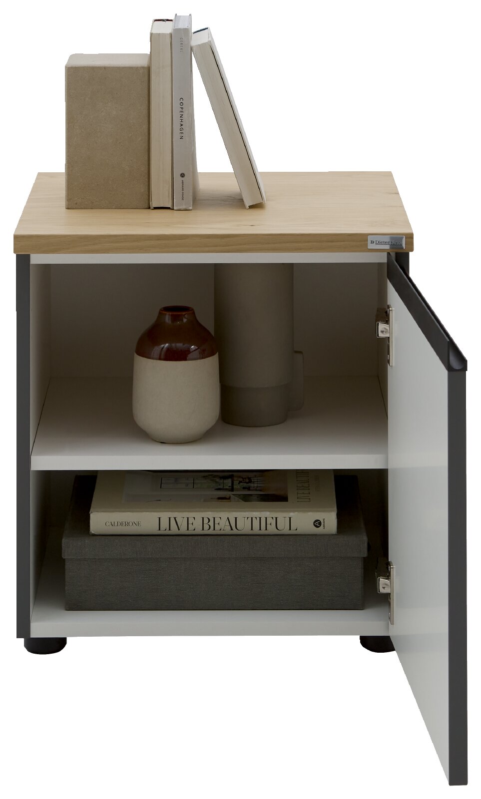 Dieter Knoll Nachtkonsole LENDINA Moderner Nachttisch/Beistellschrank mit heller Holzplatte und weißer Tür, Tür nach rechts geöffnet mit sichtbaren Regalfächern; oben Bücher, innen Vasen und Box; Perspektive: frontale Ansicht leicht von links.