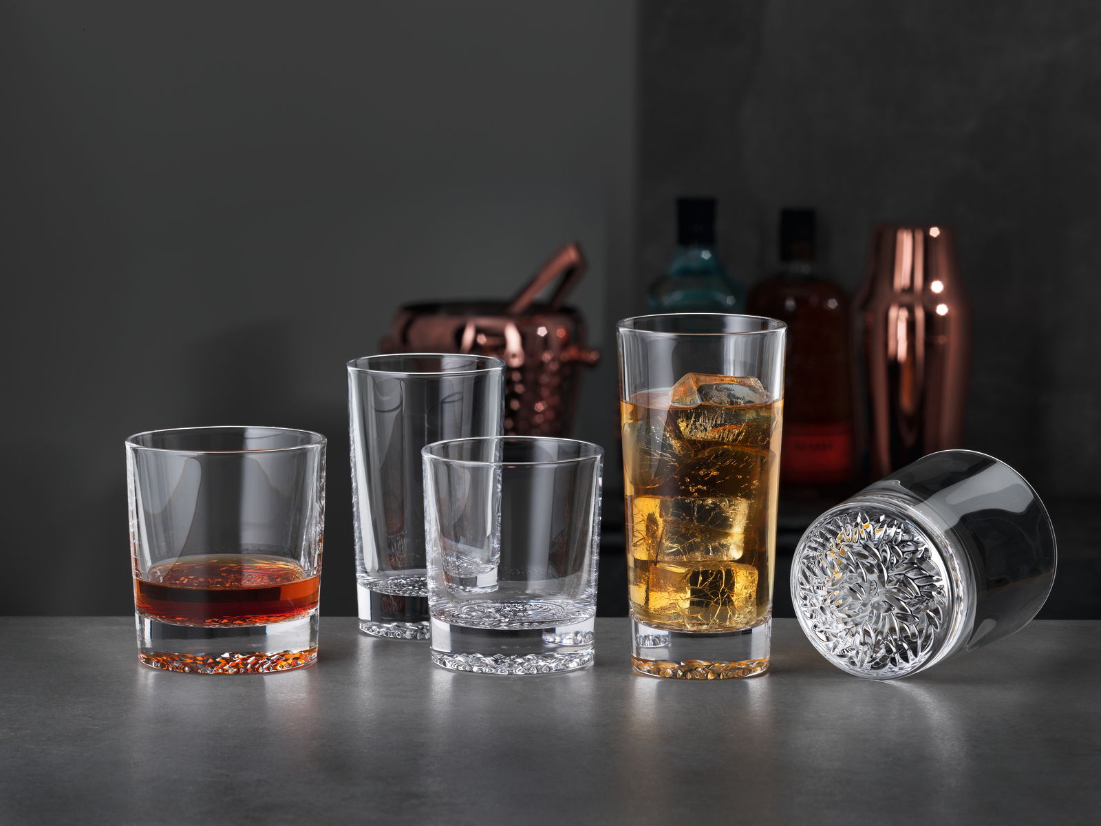 Vierer-Set von Bechern in einer eleganten Lounge-Atmosphäre, mit einem liegenden Glas im Vordergrund.