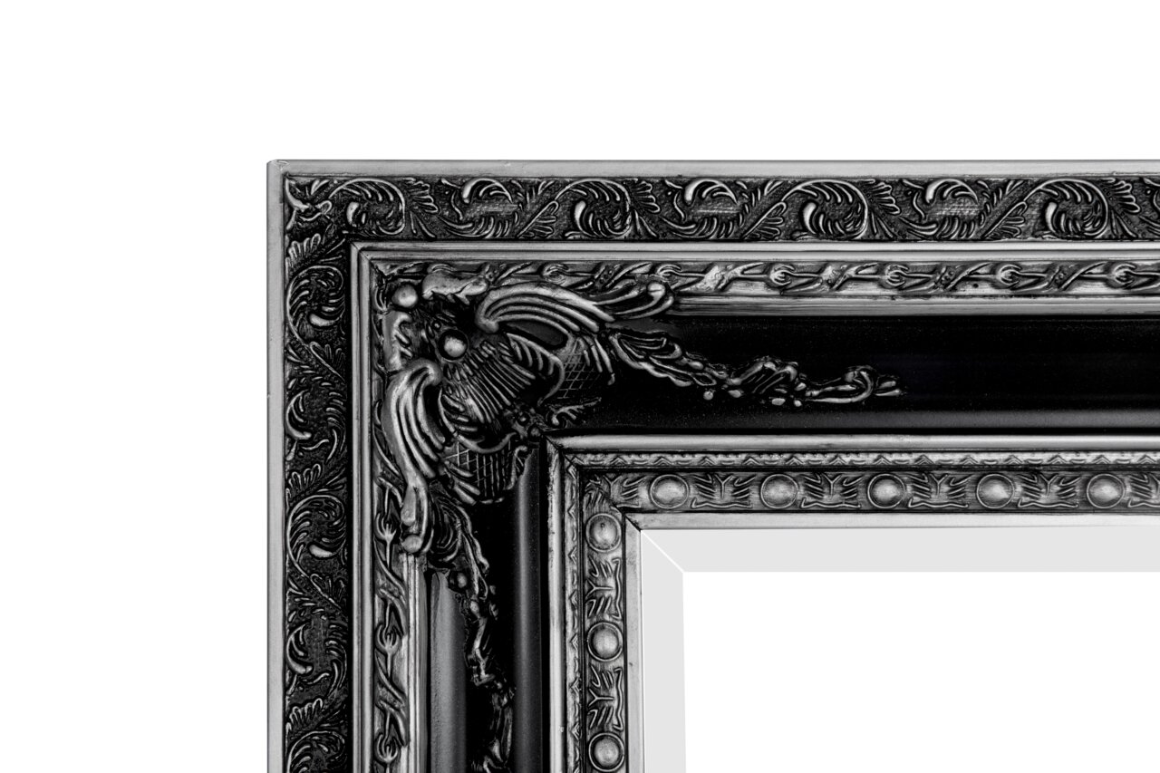Detailansicht eines kunstvoll verzierten schwarzen Spiegelrahmens mit floralen Mustern.