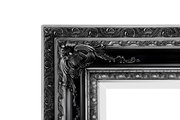 Detailansicht eines kunstvoll verzierten schwarzen Spiegelrahmens mit floralen Mustern.
