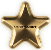 Goldener sternförmiger Deckelknopf von oben betrachtet, mit der Aufschrift 'LE CREUSET'.