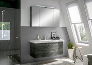 Moderne Badezimmermöbel mit Spiegelschrank und Waschbeckenunterschrank in einer hellen, stilvollen Umgebung, seitliche Perspektive.