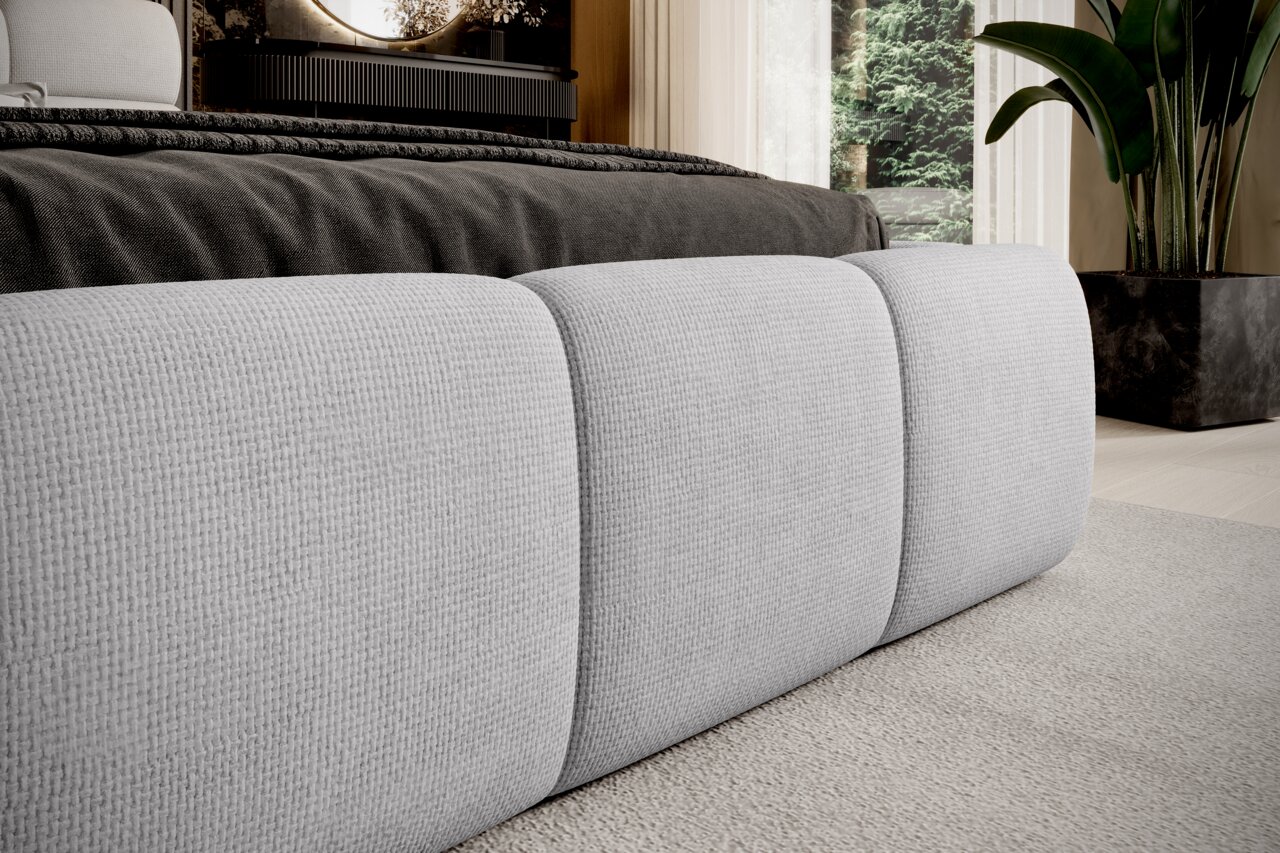 Nahaufnahme eines modernen Polsterbetts mit grauem Stoffbezug, seitliche Perspektive.