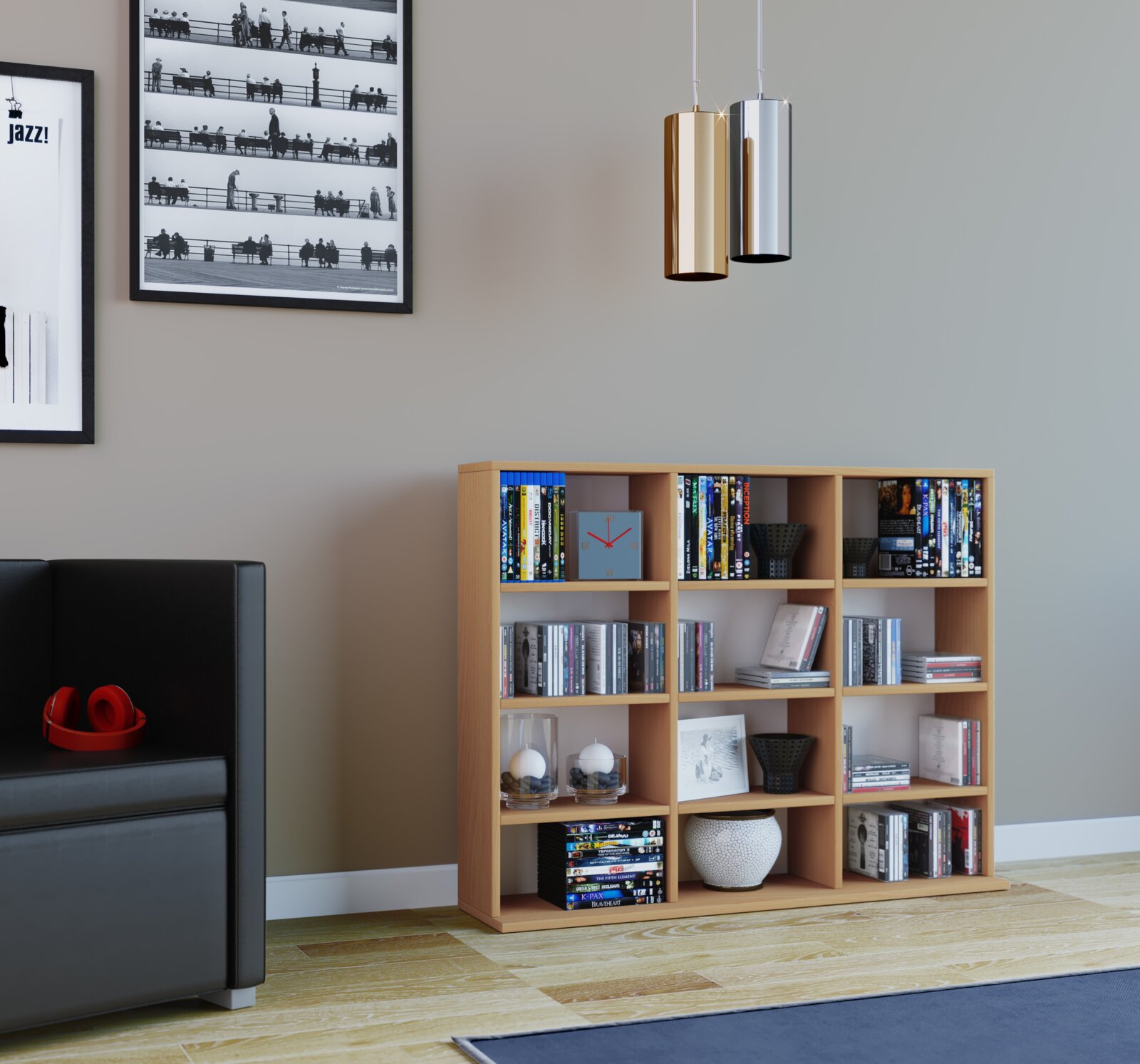 Modernes Holzregal mit vielen Fächern, gefüllt mit DVDs, Büchern und Deko, in einem Wohnzimmer; Ansicht aus frontaler Perspektive leicht von links, mit Sofa links und zwei zylindrischen Pendelleuchten oben rechts.