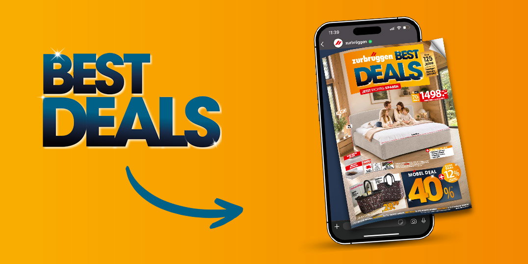 Smartphone mit digitalem Zurbrüggen-Prospekt „Best Deals“ mit Bett und Rabattangeboten, weitere Prospekte im Hintergrund.