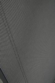 Nahaufnahme eines Stapelstuhls mit schwarzem, gewebtem Stoffbezug, von der Seite betrachtet.