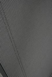 Nahaufnahme eines Stapelstuhls mit schwarzem, gewebtem Stoffbezug, von der Seite betrachtet.