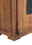Nahaufnahme eines rustikalen Sideboards aus Holz mit sichtbarer Maserung und Metallakzent, seitliche Perspektive.