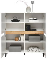 Weißes Highboard mit offenen Türen, dekoriert mit Büchern, Boxen und einer Vase, aus frontaler Perspektive.