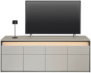 Frontale Ansicht eines modernen TV-Lowboards mit integriertem LED-Licht, einem Flachbildfernseher und einer Tischlampe.