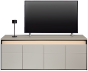 Frontale Ansicht eines modernen TV-Lowboards mit integriertem LED-Licht, einem Flachbildfernseher und einer Tischlampe.