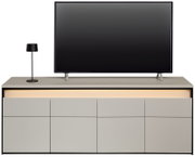 Frontale Ansicht eines modernen TV-Lowboards mit integriertem LED-Licht, einem Flachbildfernseher und einer Tischlampe.