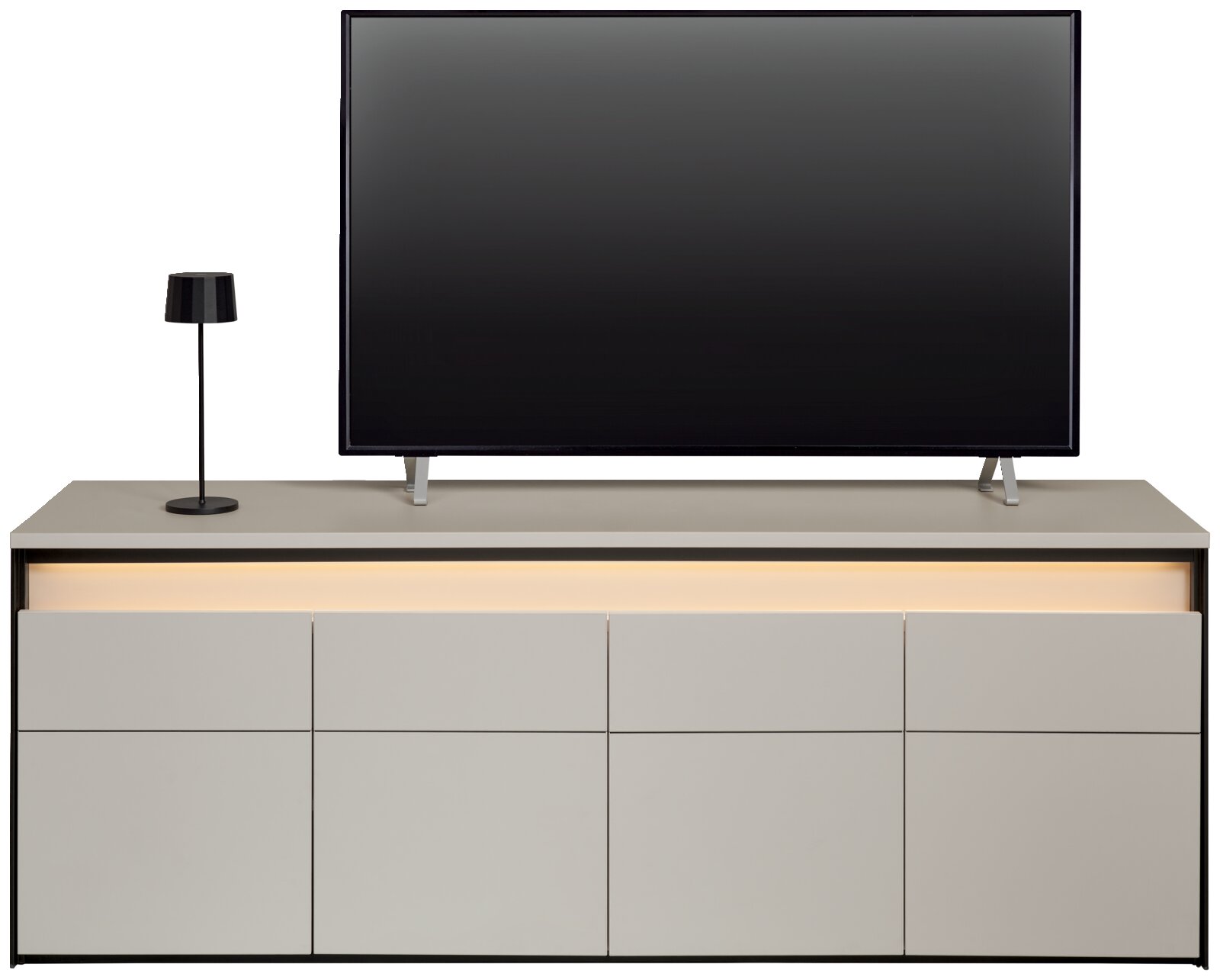 Vooraanzicht van een modern tv-lowboard met ingebouwde ledverlichting, een flatscreen-tv en een tafellamp.
