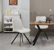 Moderner Polsterstuhl in Hellbeige mit schwarzem Metallgestell neben Holztisch im Essbereich, fotografiert in leichter Seitenansicht auf Augenhöhe.