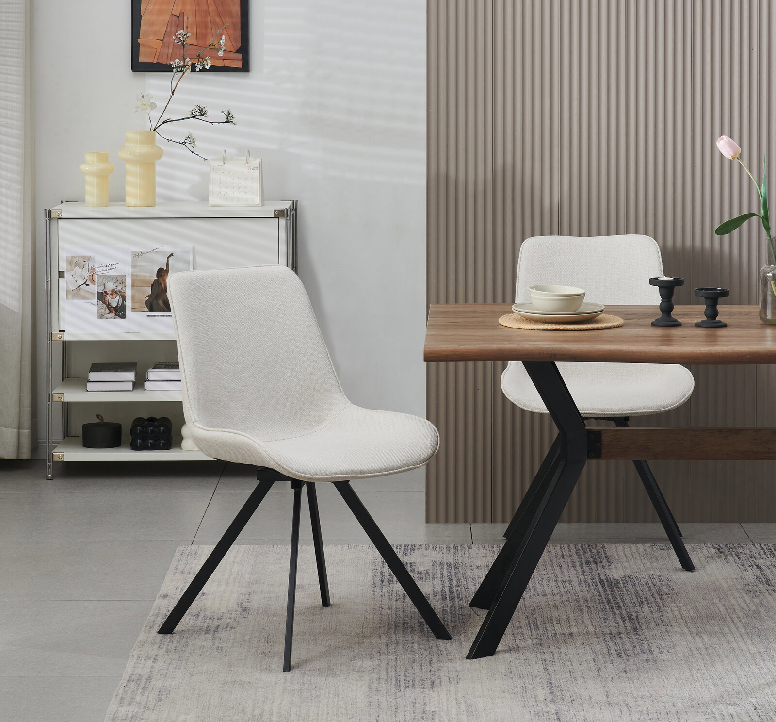 Moderner Polsterstuhl in Hellbeige mit schwarzem Metallgestell neben Holztisch im Essbereich, fotografiert in leichter Seitenansicht auf Augenhöhe.