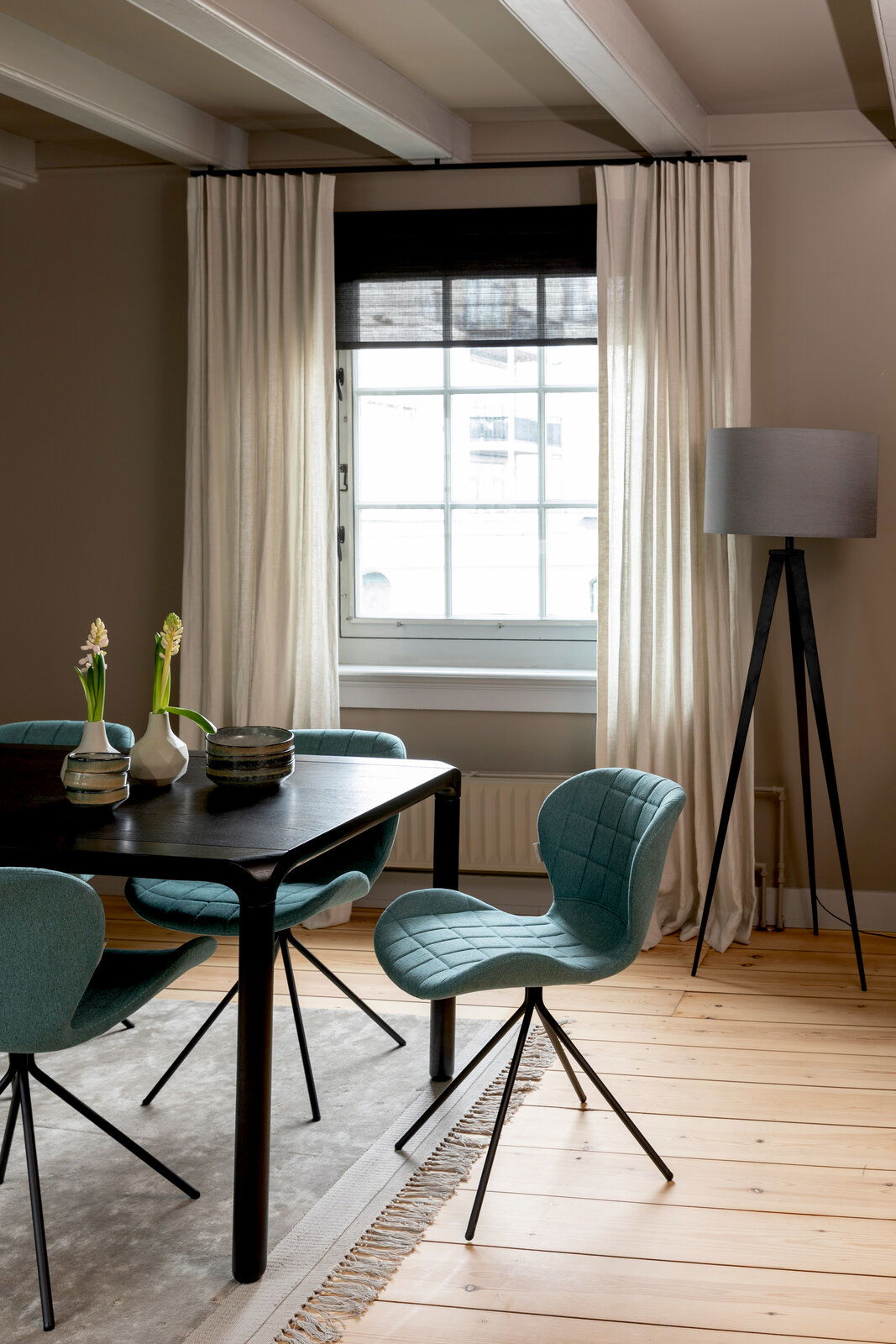 Z2 Stuhl OMG Moderner Esszimmerstuhl mit gepolstertem, türkisfarbenem Sitz und schwarzem Metallgestell, seitliche Perspektive.