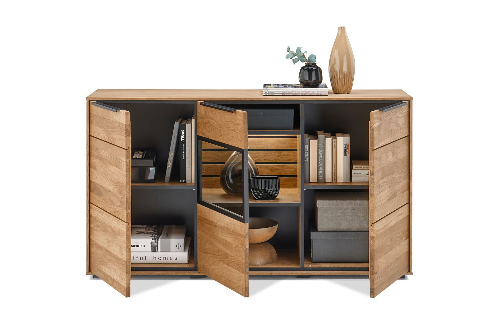 Set one by Musterring Sideboard SET ONE JACKSON Frontale Ansicht eines modernen Sideboards aus Holz mit offenen und geschlossenen Fächern, dekoriert mit Büchern, Vasen und Schalen.