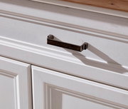 Nahaufnahme eines weißen Schranks mit dunklem Metallgriff, seitliche Perspektive