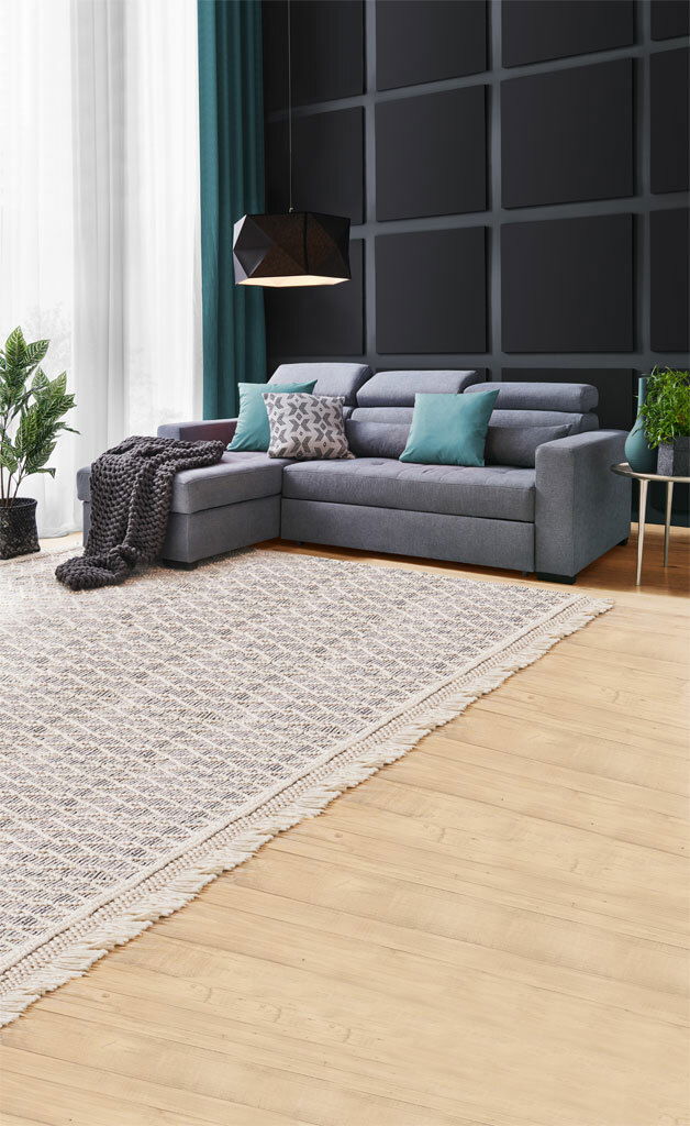 Graue Rundecke (L) in modernem Wohnzimmer mit Kissen und Decke, seitliche Perspektive