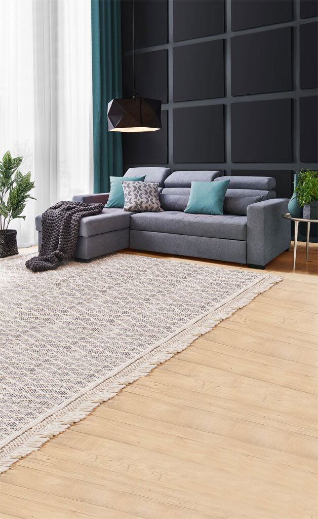 Graue Rundecke (L) in modernem Wohnzimmer mit Kissen und Decke, seitliche Perspektive