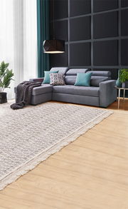 Graue Rundecke (L) in modernem Wohnzimmer mit Kissen und Decke, seitliche Perspektive