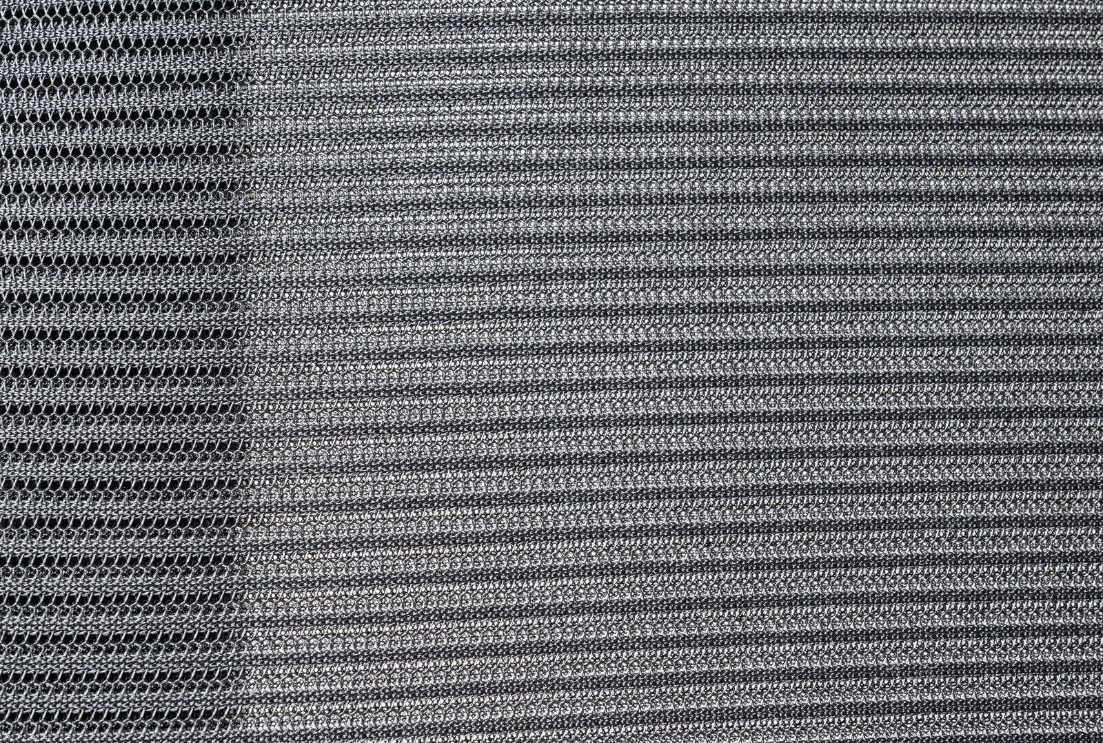 Nahaufnahme des Stoffmusters eines Drehstuhls in grauer Farbe, von oben betrachtet.
