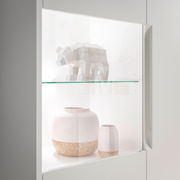 Nahaufnahme eines Highboards mit Glasvitrine, in der ein geometrisches Tiermodell und zwei dekorative Vasen ausgestellt sind.