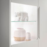 Nahaufnahme eines Highboards mit Glasvitrine, in der ein geometrisches Tiermodell und zwei dekorative Vasen ausgestellt sind.