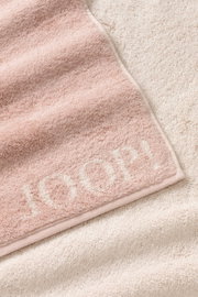 Nahaufnahme eines weichen, rosa Gästetuchs mit dem Schriftzug 'JOOP!' in hellerem Ton.