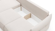 Beiges Polster-Ecksofa mit geöffnetem Stauraumfach aus weißem Innenkorpus und Holzdetails, schräg von oben in Perspektive aufgenommen