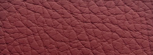 Nahaufnahme der strukturierten, roten Lederoberfläche eines Sessels