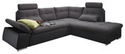Ecksofa in dunklem Stoff mit verstellbaren Kopfstützen und einem grünen Kissen, seitliche Perspektive