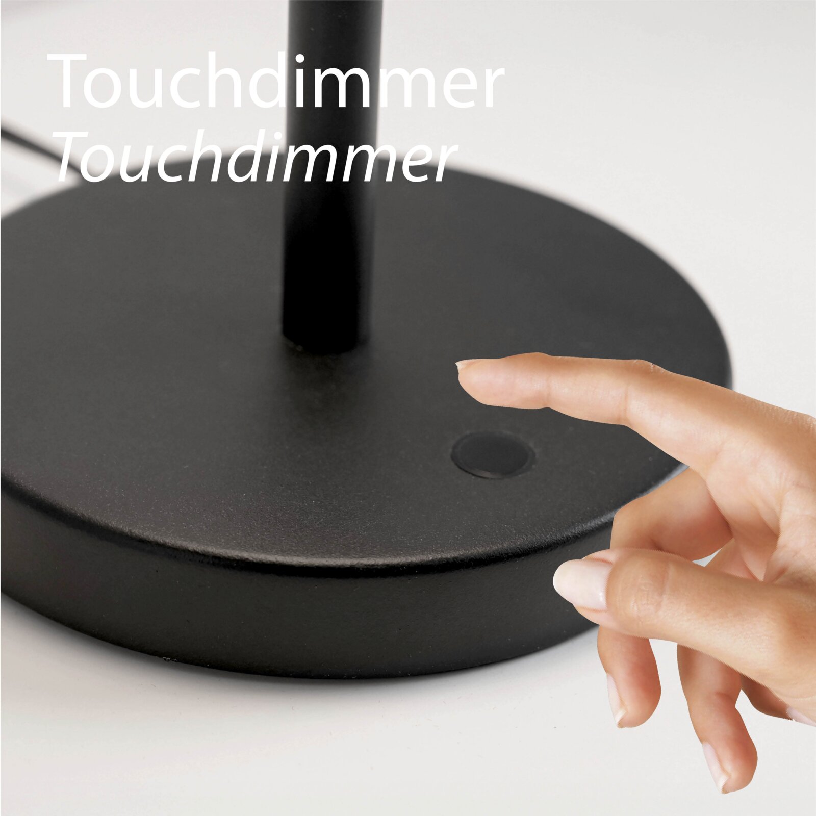 Nahaufnahme aus leicht schräger Vorderansicht: schwarzer Lampenfuß mit Touchdimmer-Taste, ein Finger berührt den Dimmer.