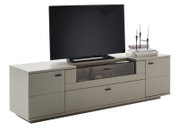 Modern tv-lowboard in taupe/grijs met lades en een vak van getint glas, met tv en decoratie op een witte achtergrond, schuin vooraanzicht