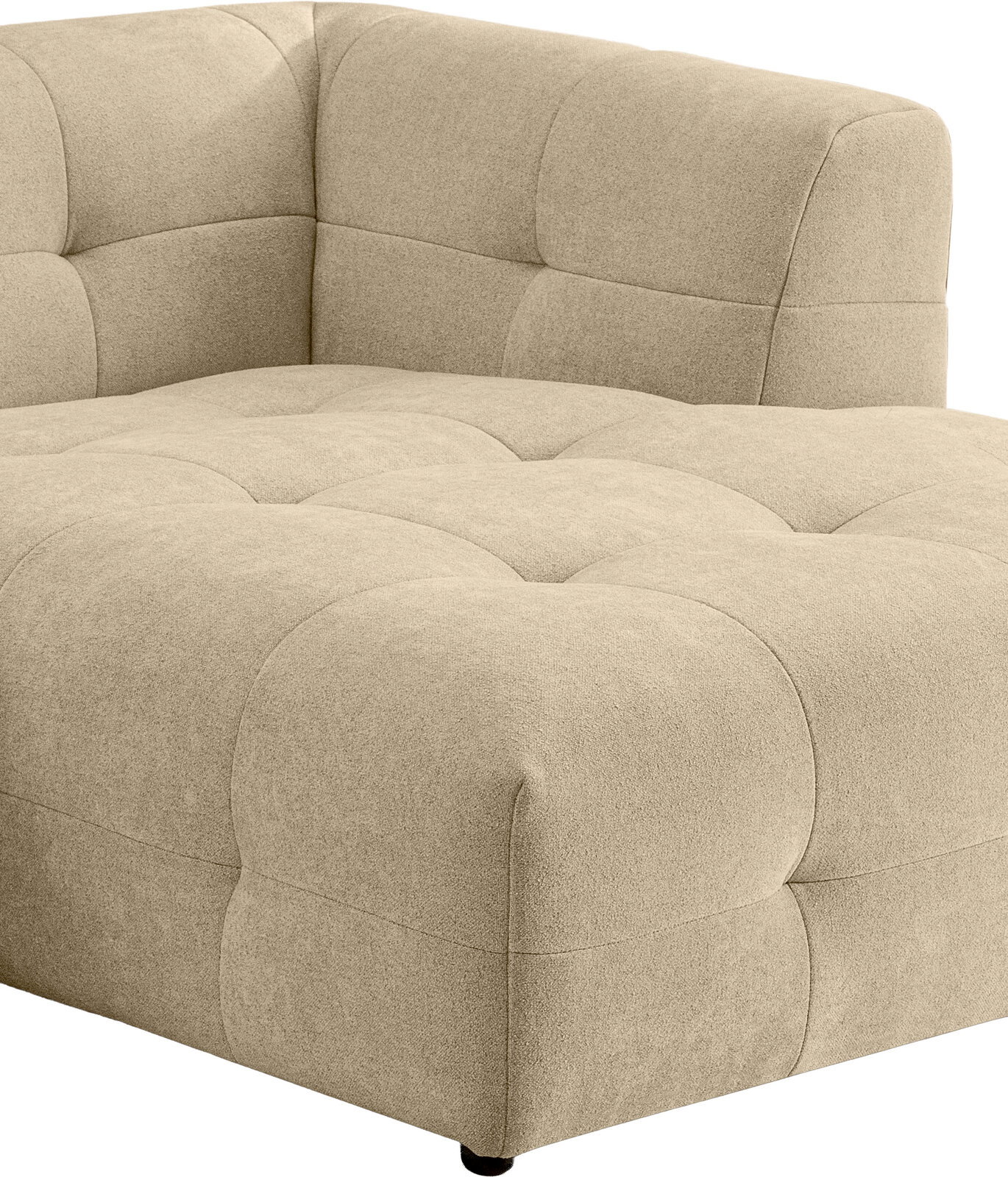 Beiger, gepolsterter Lounge-Sessel mit gesteppter Sitzfläche und abgerundeter Rückenlehne, Ansicht schräg von vorne rechts