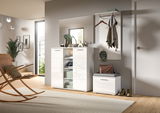 Moderne weiße Kommode mit Hochglanzoberfläche, frontal fotografiert, in einem stilvoll eingerichteten Raum mit Dekorationen und Pflanzen.