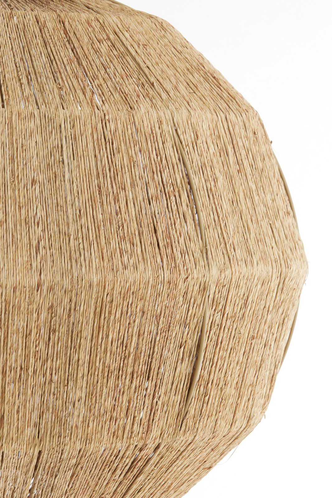 Nahaufnahme einer Hängeleuchte mit natürlichem, geflochtenem Material in beige.