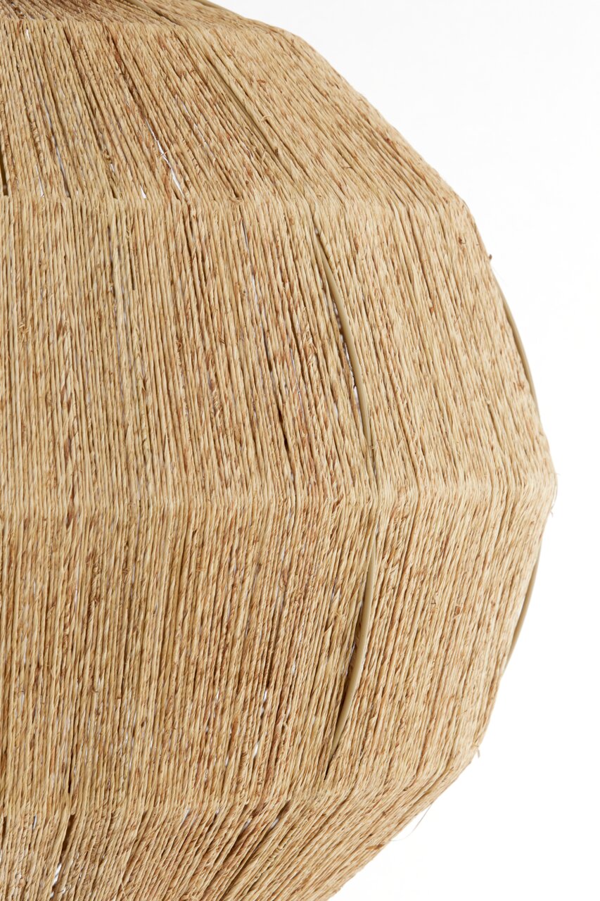 Close-up van een hanglamp van natuurlijk, gevlochten materiaal in beige.