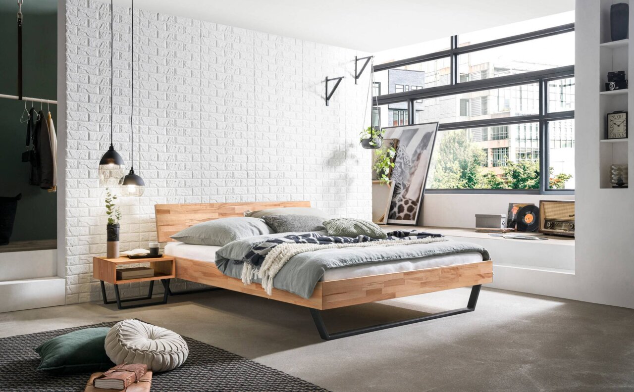 Moderne slaapkamer met een stijlvol bedframe van hout en metaal, gezien vanaf de zijkant. De kamer is licht en minimalistisch ingericht, met grote ramen en decoratieve elementen.