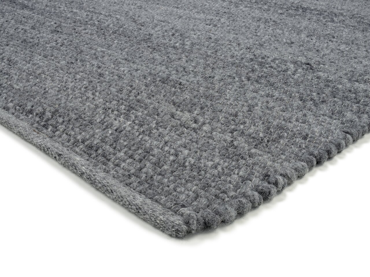 Grauer Handweb Teppich in Nahaufnahme, perspektivisch von der Seite fotografiert.