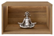 Silberfarbene Dekofigur eines meditierenden Hundes in Yoga-Pose auf einem Holzregal, Frontalansicht