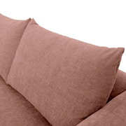 Nahaufnahme einer rosafarbenen Sofaecke mit Kissen, seitliche Perspektive