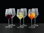 Set aus sechs eleganten Spritz- und Rotweingläsern mit geriffeltem Design, gefüllt mit verschiedenen Getränken, aus frontaler Perspektive fotografiert.
