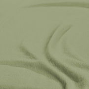 Nahaufnahme eines grünen Spannbetttuchs mit weicher Textur.