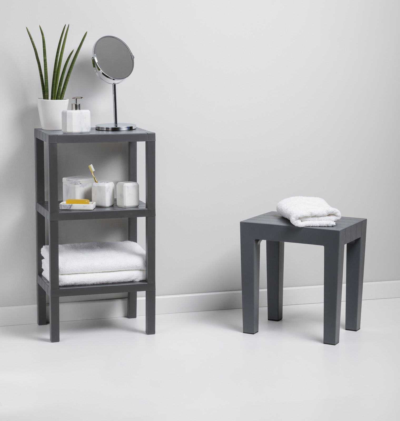 Graues, rechteckiges 3-stufiges Regal mit verschiedenen Badezimmerartikeln, seitliche Perspektive.