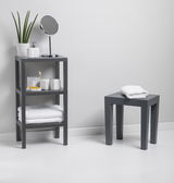 Graues, rechteckiges 3-stufiges Regal mit verschiedenen Badezimmerartikeln, seitliche Perspektive.