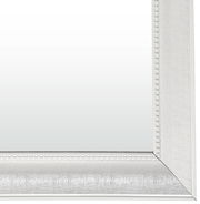 Detailansicht eines rechteckigen Spiegels mit weißem, verziertem Rahmen.