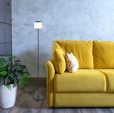 Stehleuchte GREGOIR neben einem gelben Sofa, mit Blick auf die Lampe von vorne.