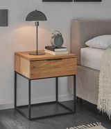 Moderne Nachtkommode aus Holz mit Metallgestell, seitliche Perspektive, dekoriert mit Tischlampe, Wecker und Büchern.